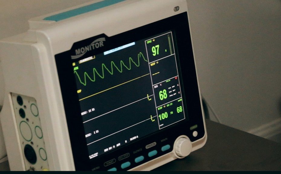 Monitor hospitalar ligado mostrando números e frequência cardíaca