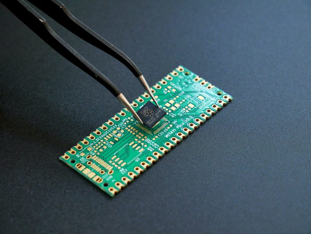 Pinça pegando um dos componentes de um circuito integrado