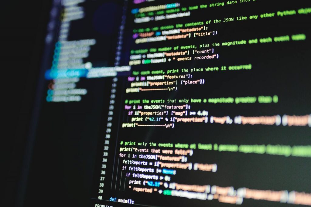Tela de computador exibindo código Python com destaque de sintaxe colorida. O script processa dados JSON e filtra eventos com base em propriedades como magnitude e relatos sentidos, ilustrando o uso de protocolos de comunicação para interpretar e exibir informações estruturadas em aplicações de software.